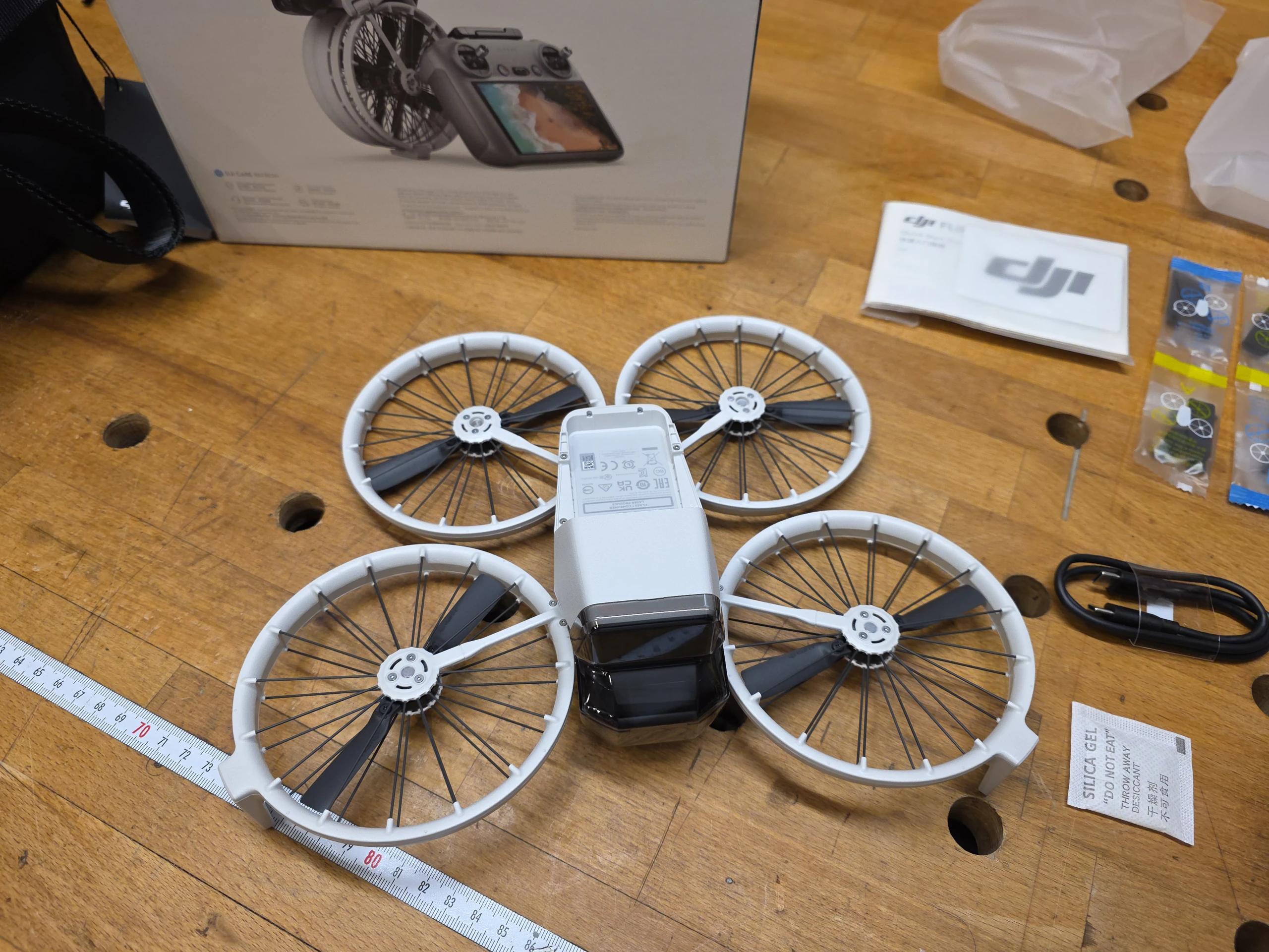 die ausgeklappte DJI Flip Drohne auf einer Holzwerkbank bereit für die technische Inbetriebnahme