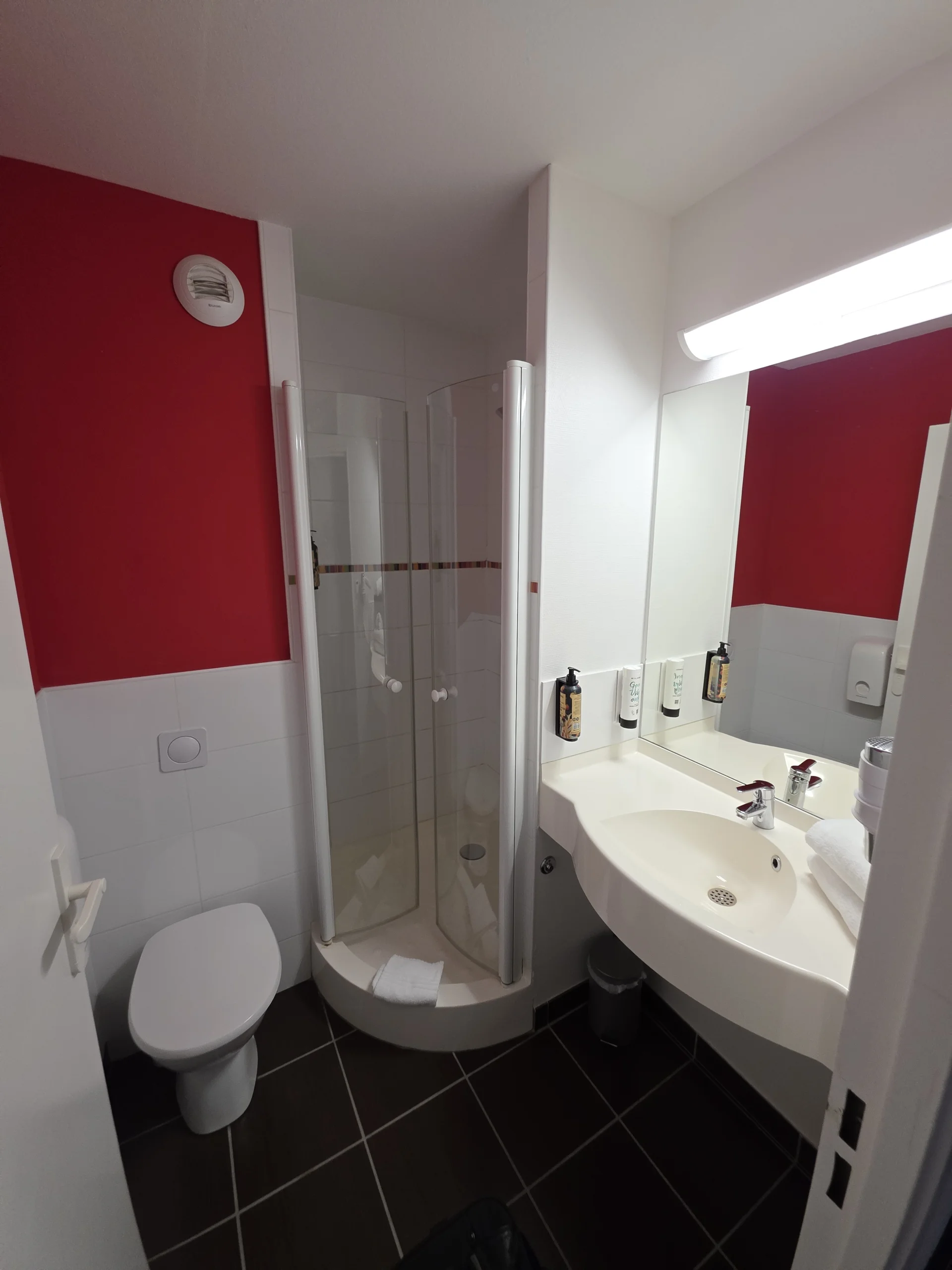 Sauberes Badezimmer mit Dusche und Waschtisch im Hotel Clermont Estaing