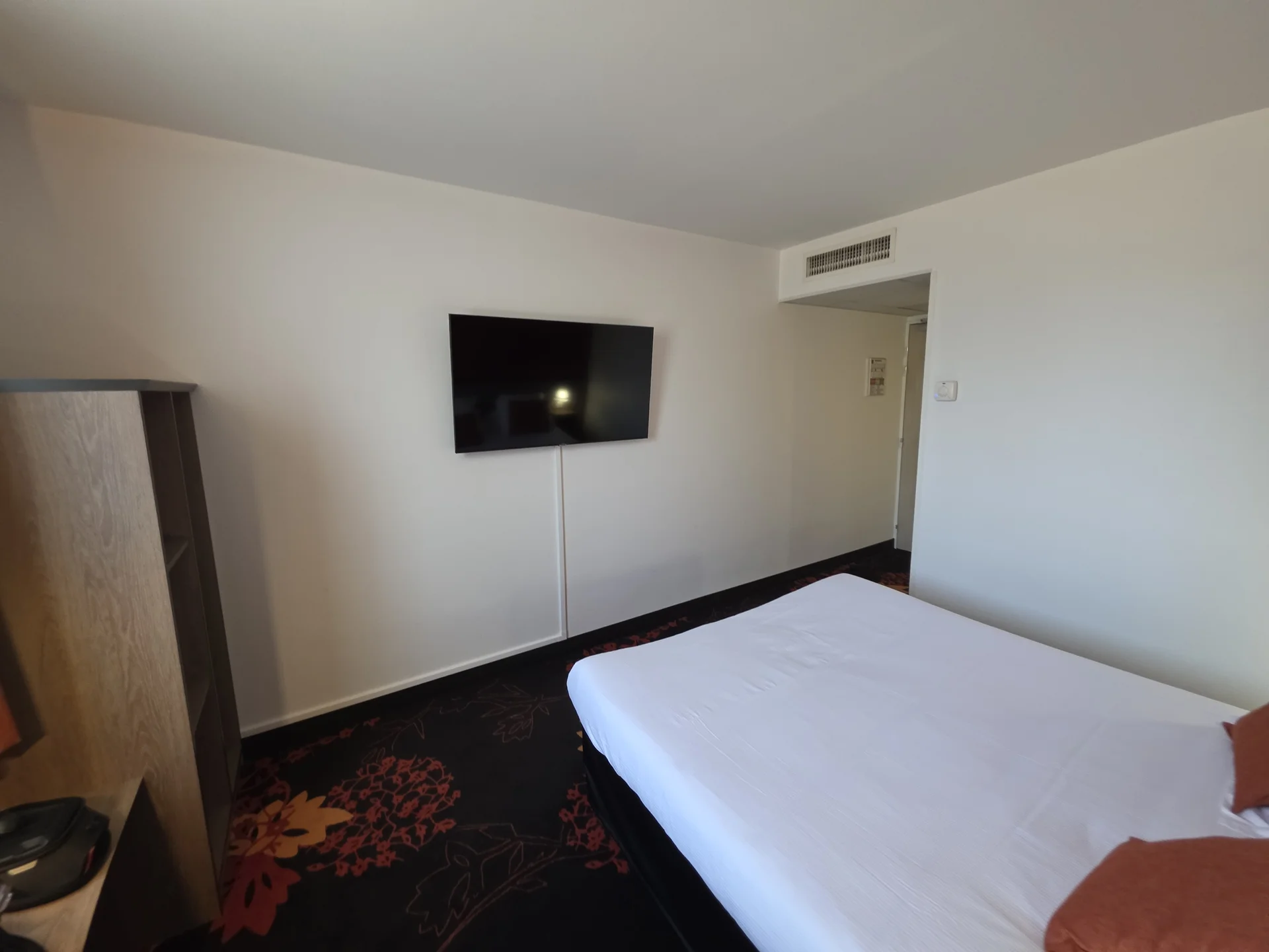 Zimmer im Hotel Clermont Estaing mit großem Fernseher und Luftauslass der Klimaanlage