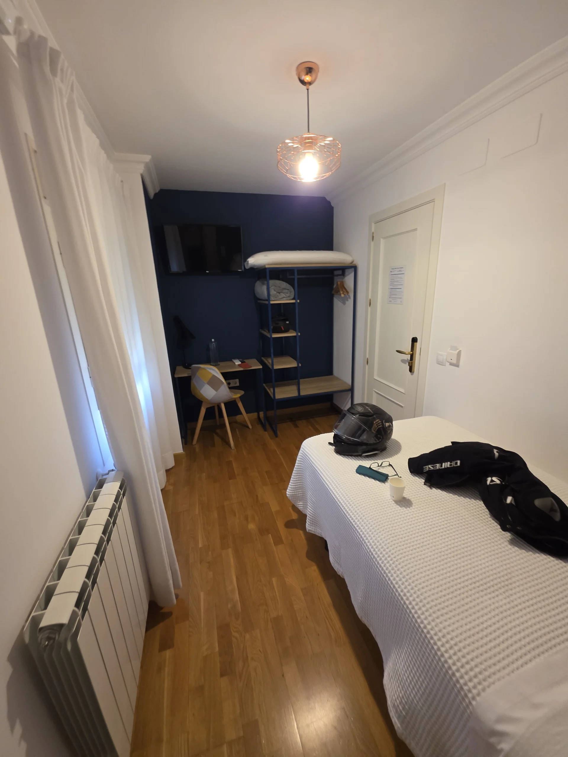 Einzelzimmer mit Schreibtisch, offenen Ablagen und Garderobe im Pura Vida Pirineos