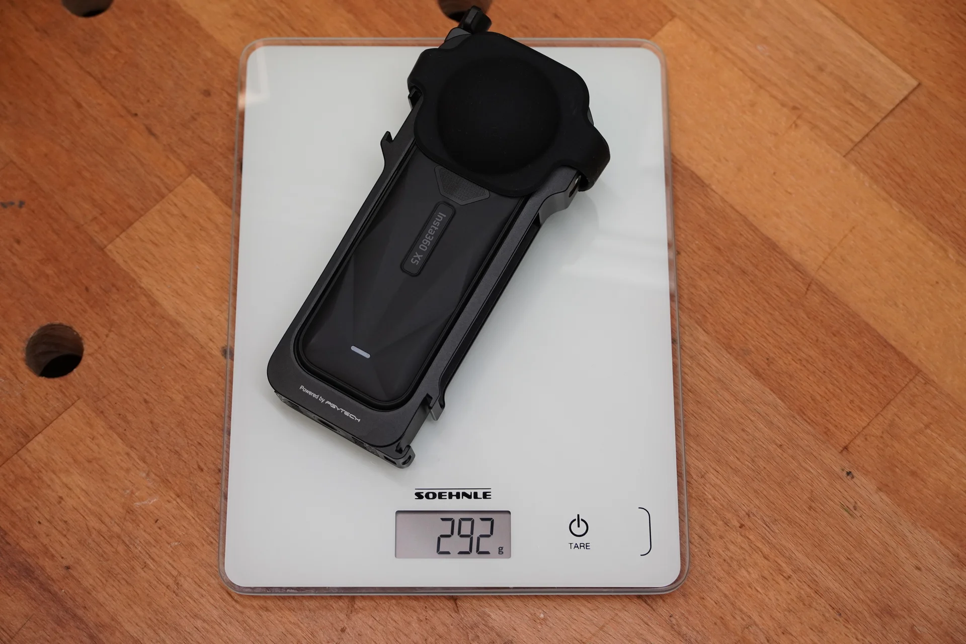 Insta360 X5 mit montiertem Zubehör auf einer digitalen Küchenwaage mit angezeigten 292 Gramm.